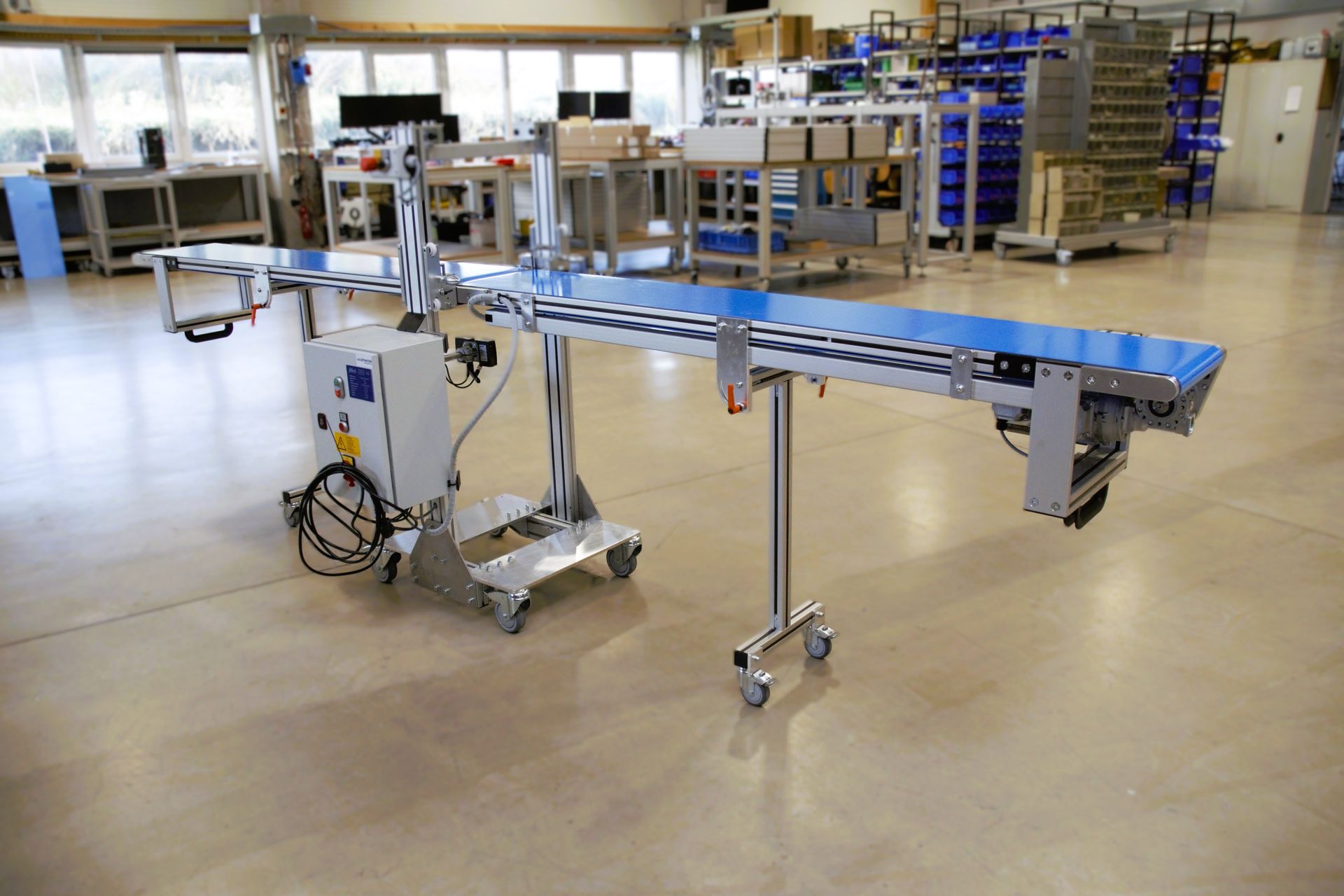 In einem großen Raum in einer Fabrik steht ein Förderband.