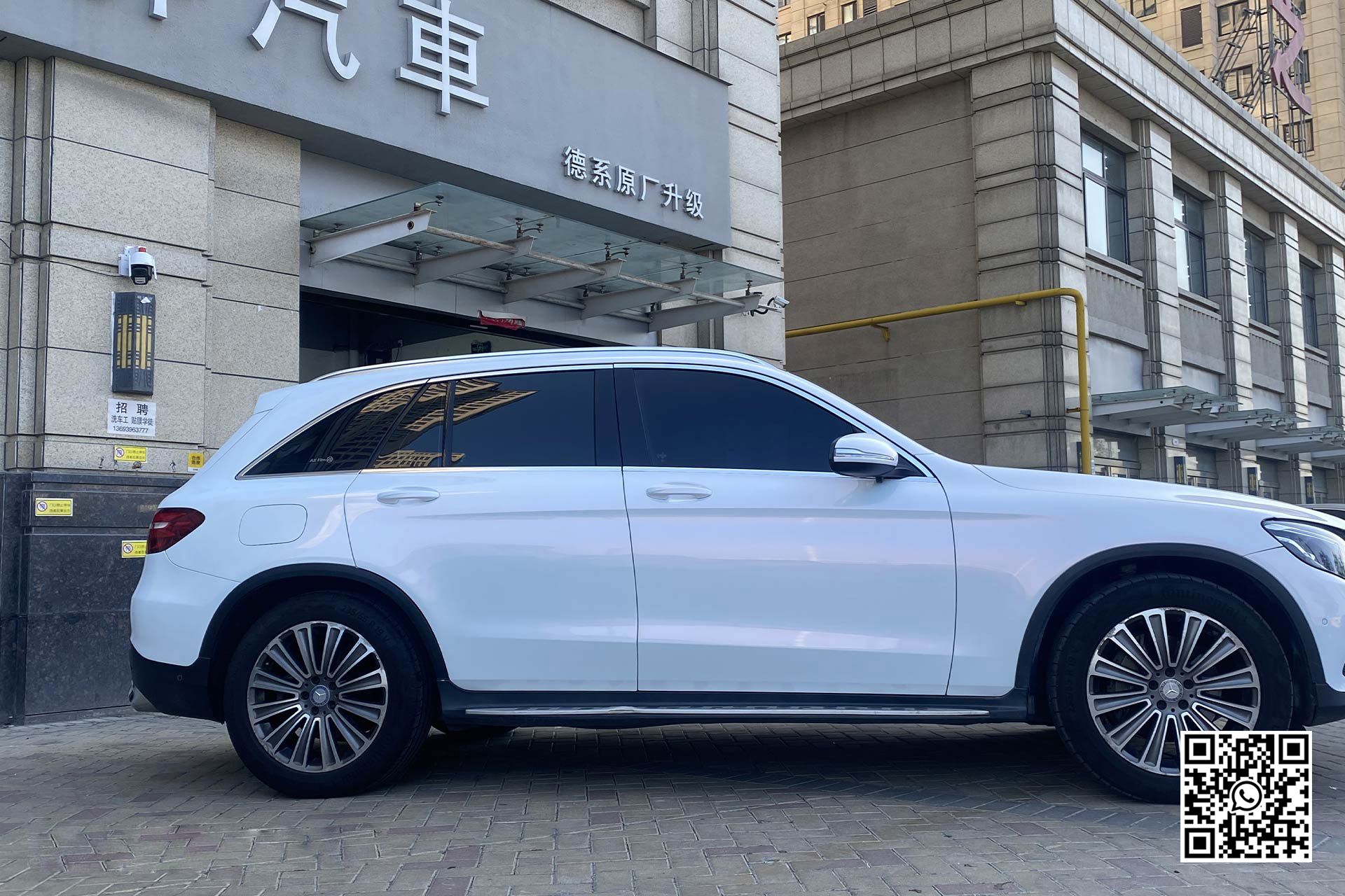 un suv bianco è parcheggiato davanti a un edificio .