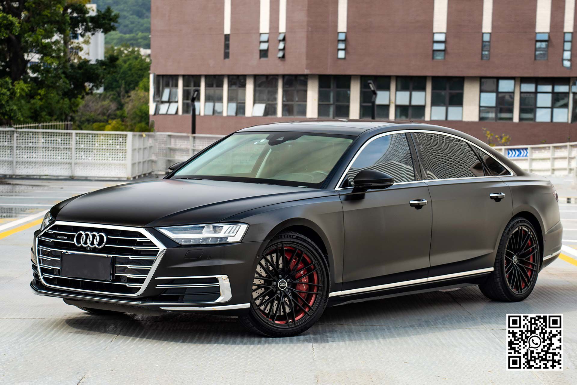 un'audi a8 è parcheggiata in un parcheggio davanti a un edificio .