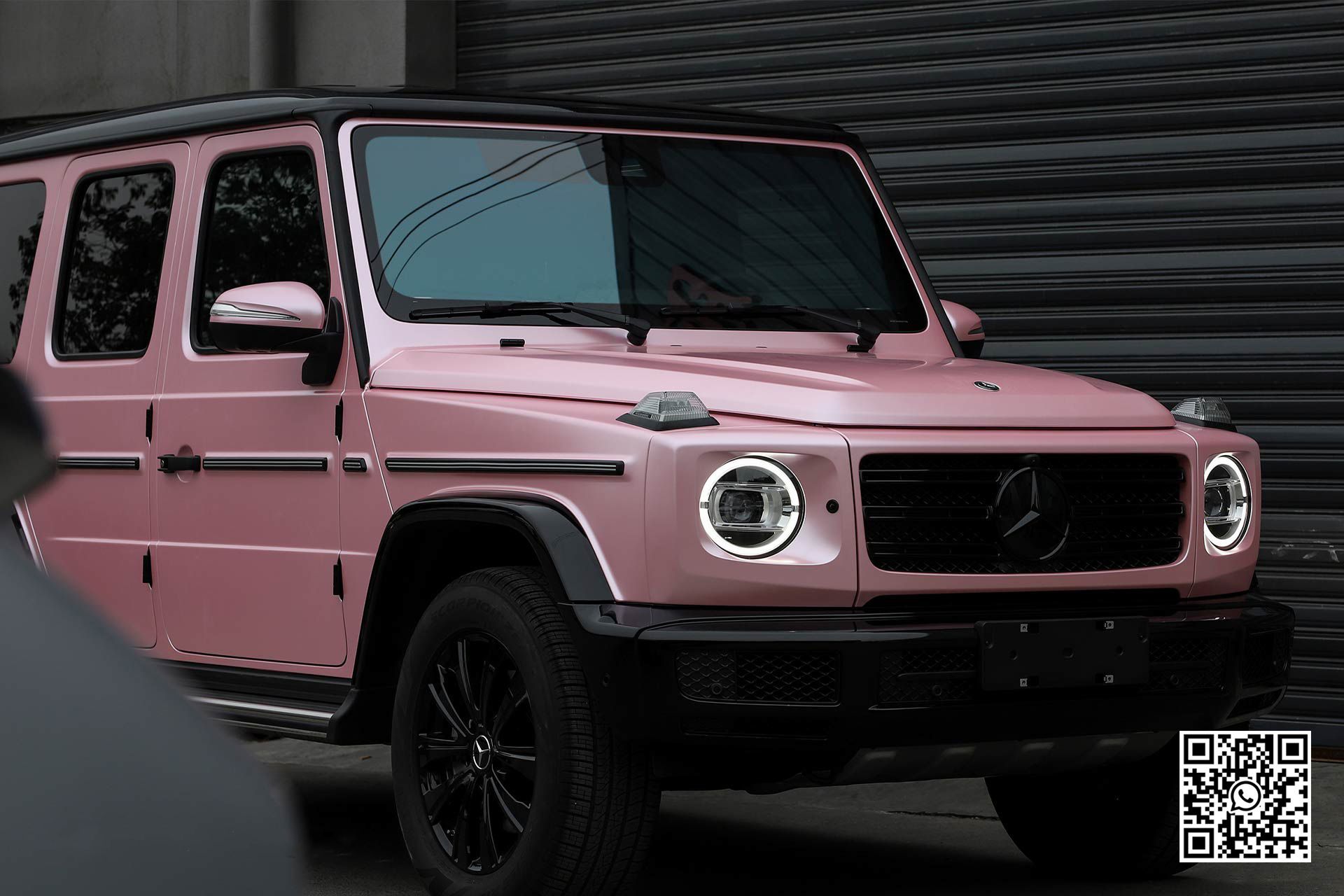 una jeep rosa è parcheggiata davanti a un garage .