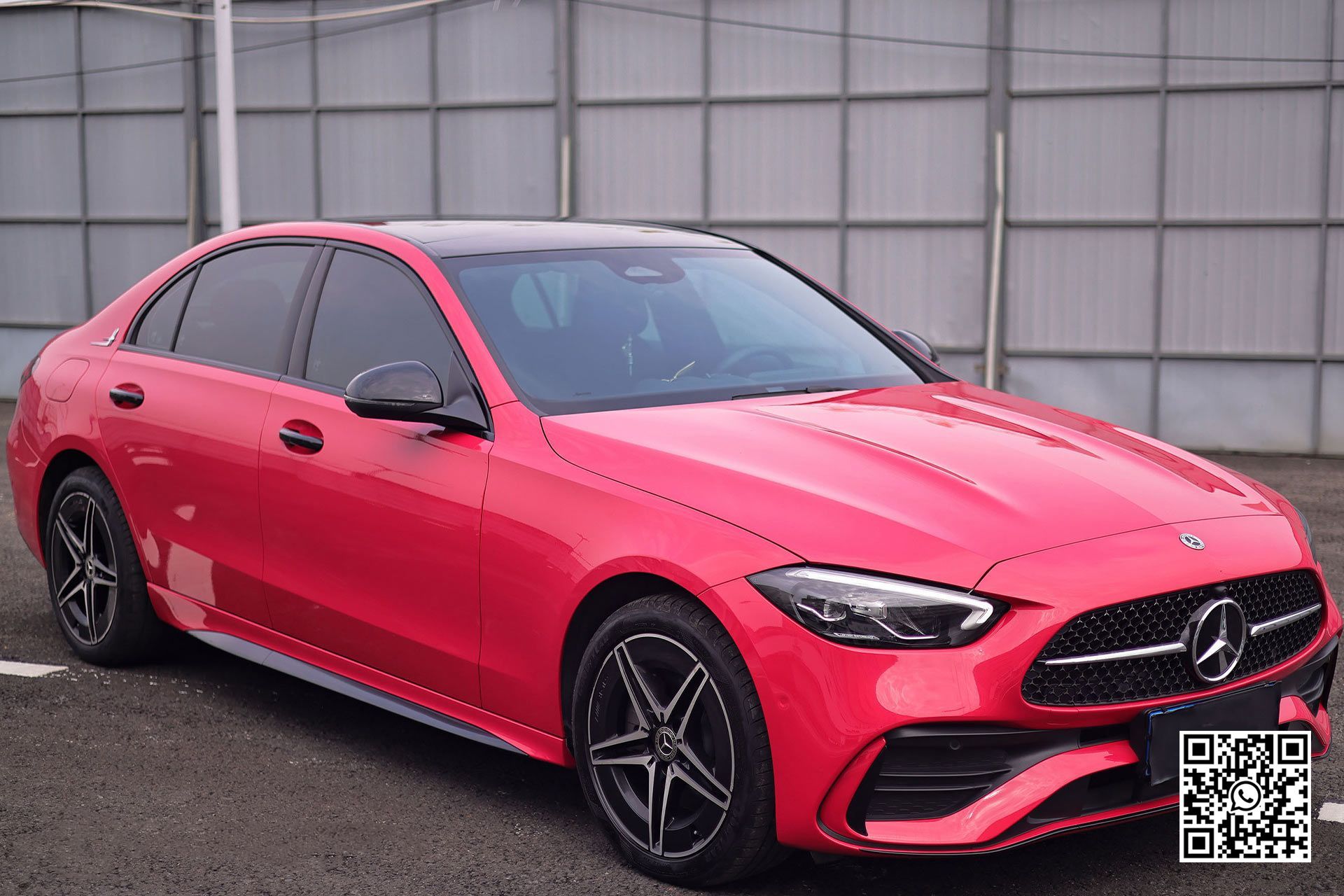 una mercedes benz c class rossa è parcheggiata in un parcheggio .