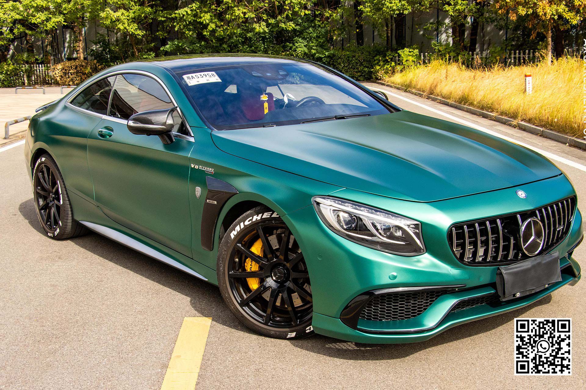 una mercedes benz s63 amg coupe verde è parcheggiata su una strada .