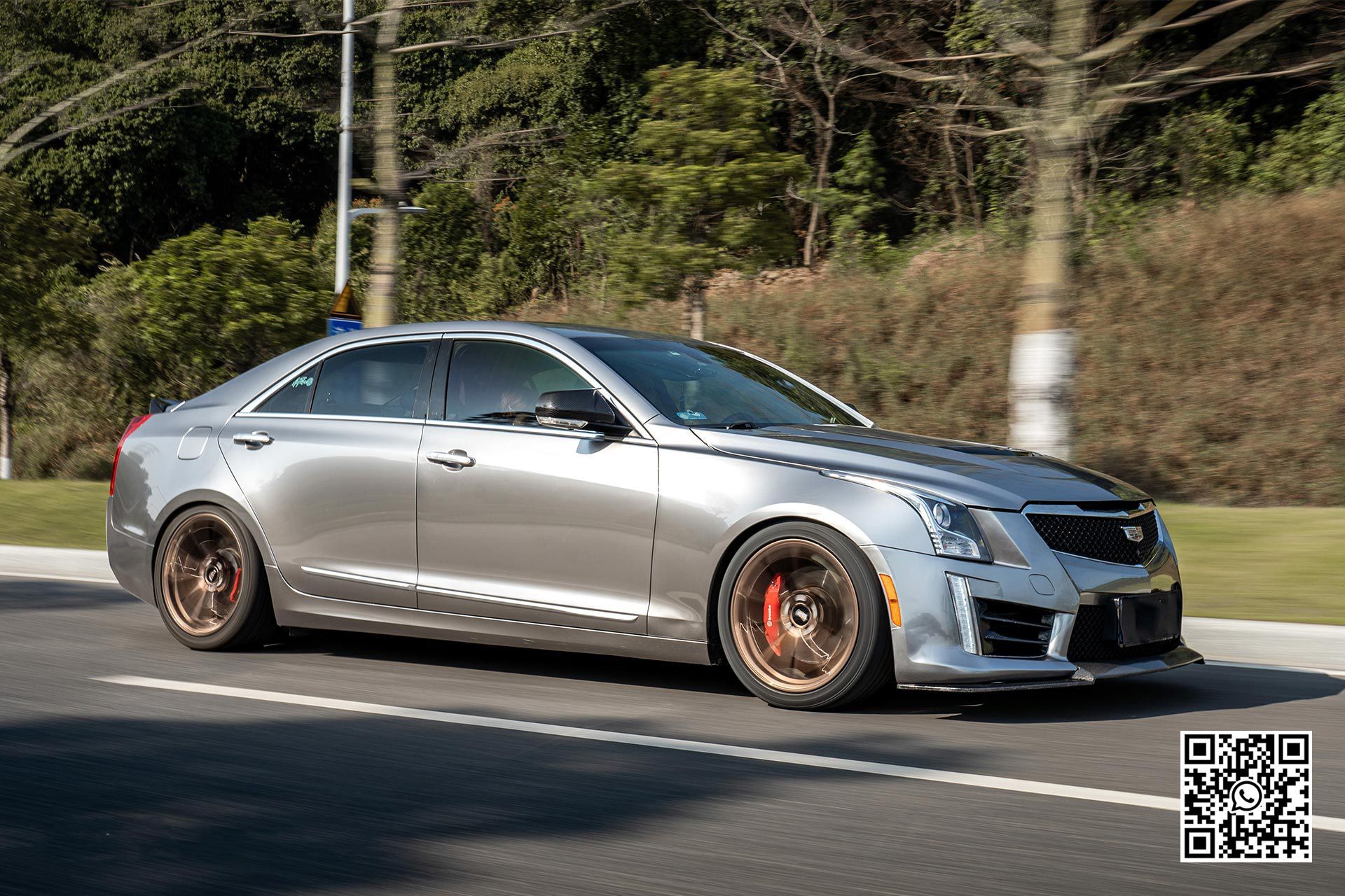 un'auto argento è parcheggiata in mezzo alla strada .