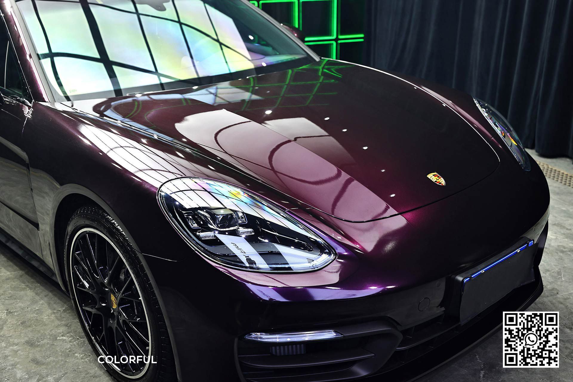 una porsche panamera viola è parcheggiata in un garage .