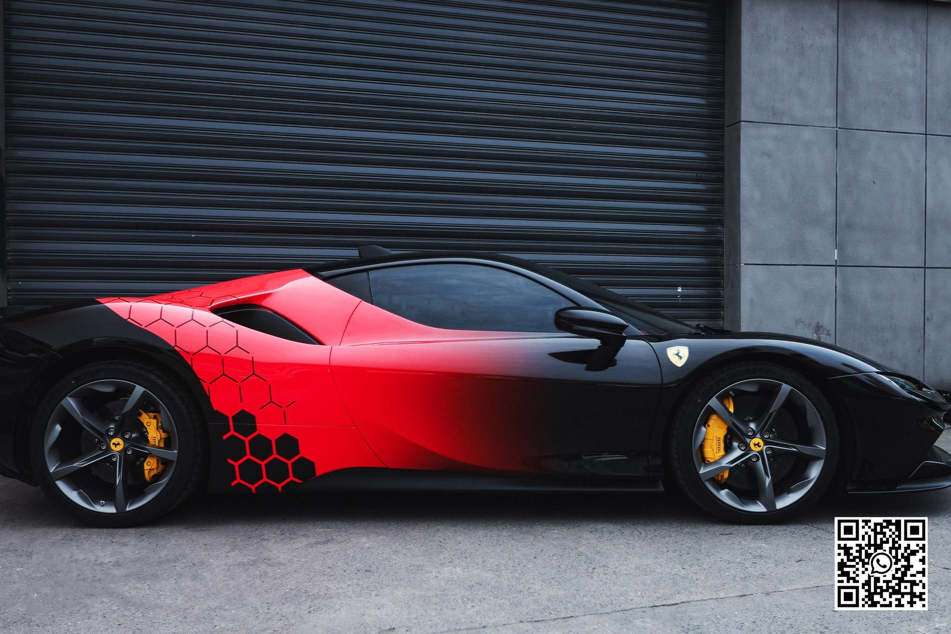 una ferrari nera e rossa è parcheggiata davanti a un garage .