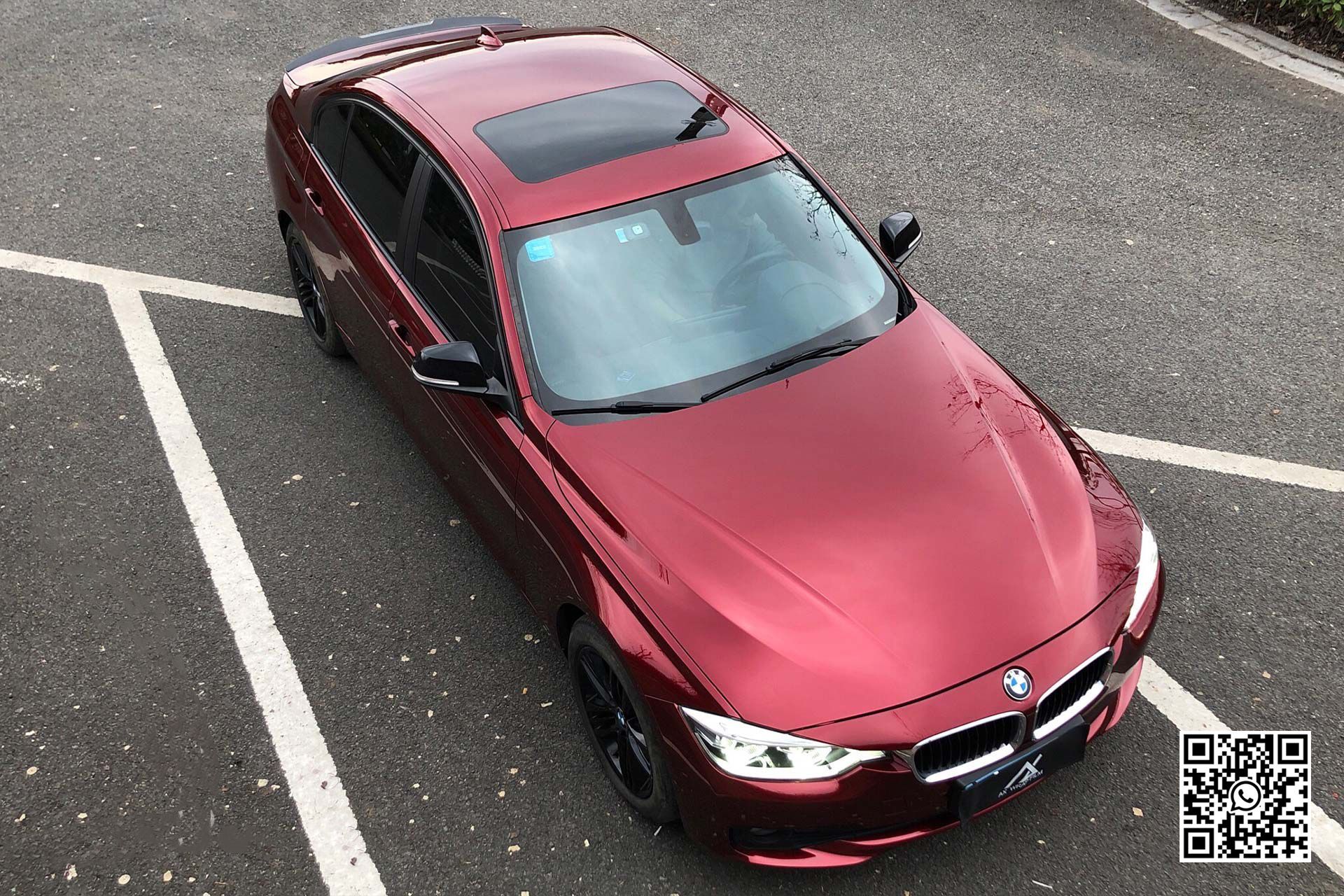 una bmw rossa è parcheggiata in un parcheggio .