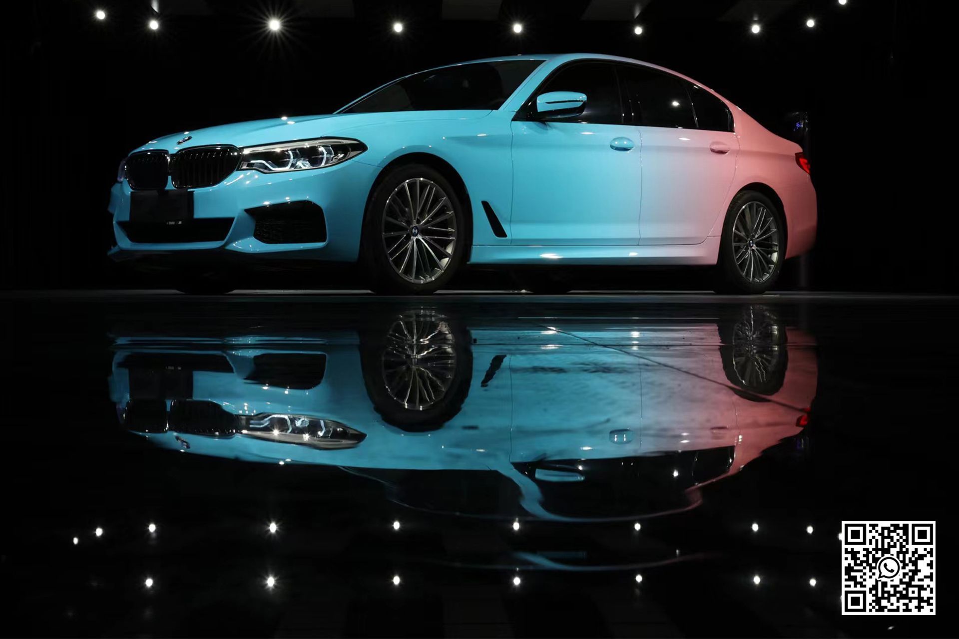 una bmw bianca è parcheggiata in un garage e si riflette nell'acqua .