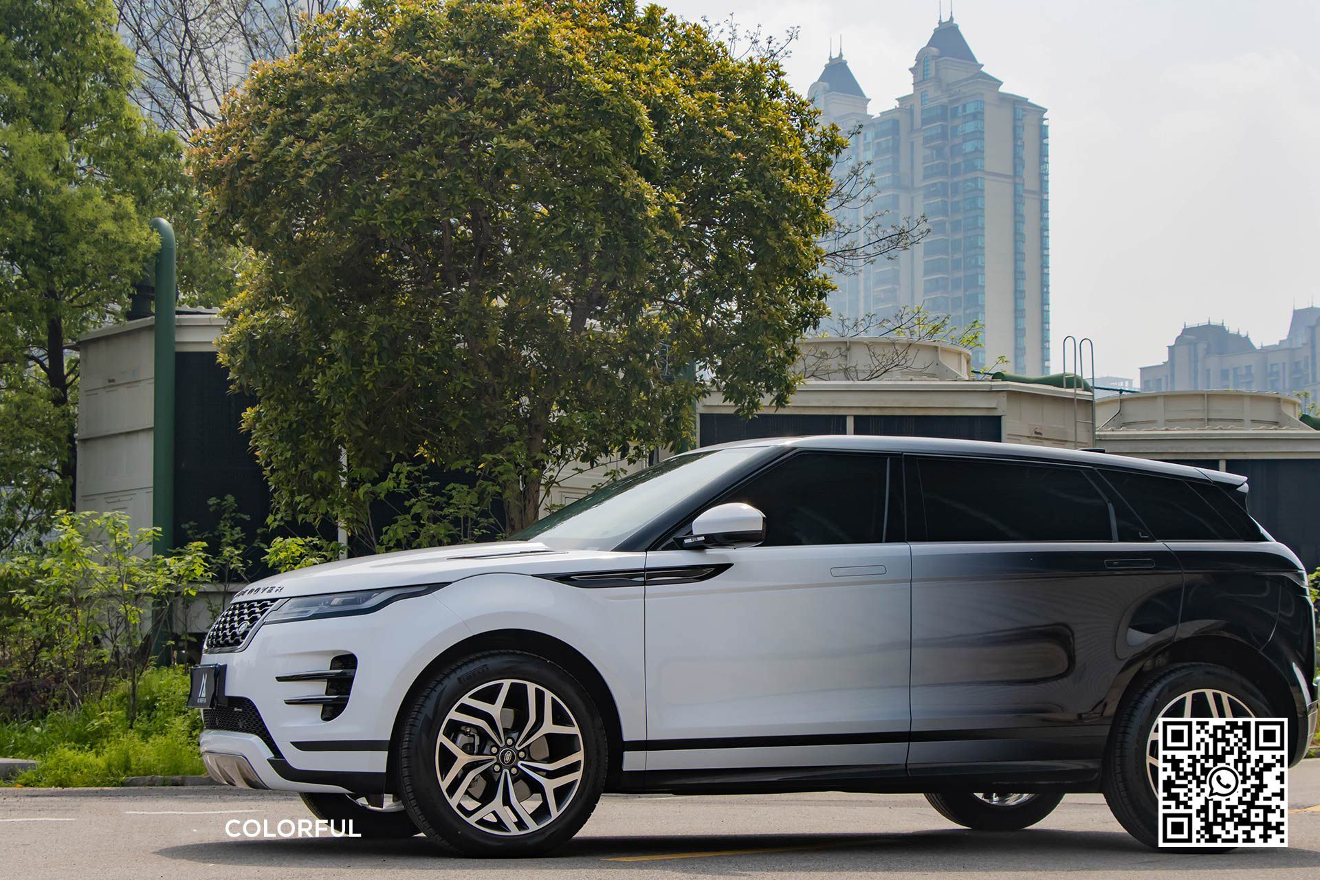 un suv bianco è parcheggiato su una strada accanto a un albero .