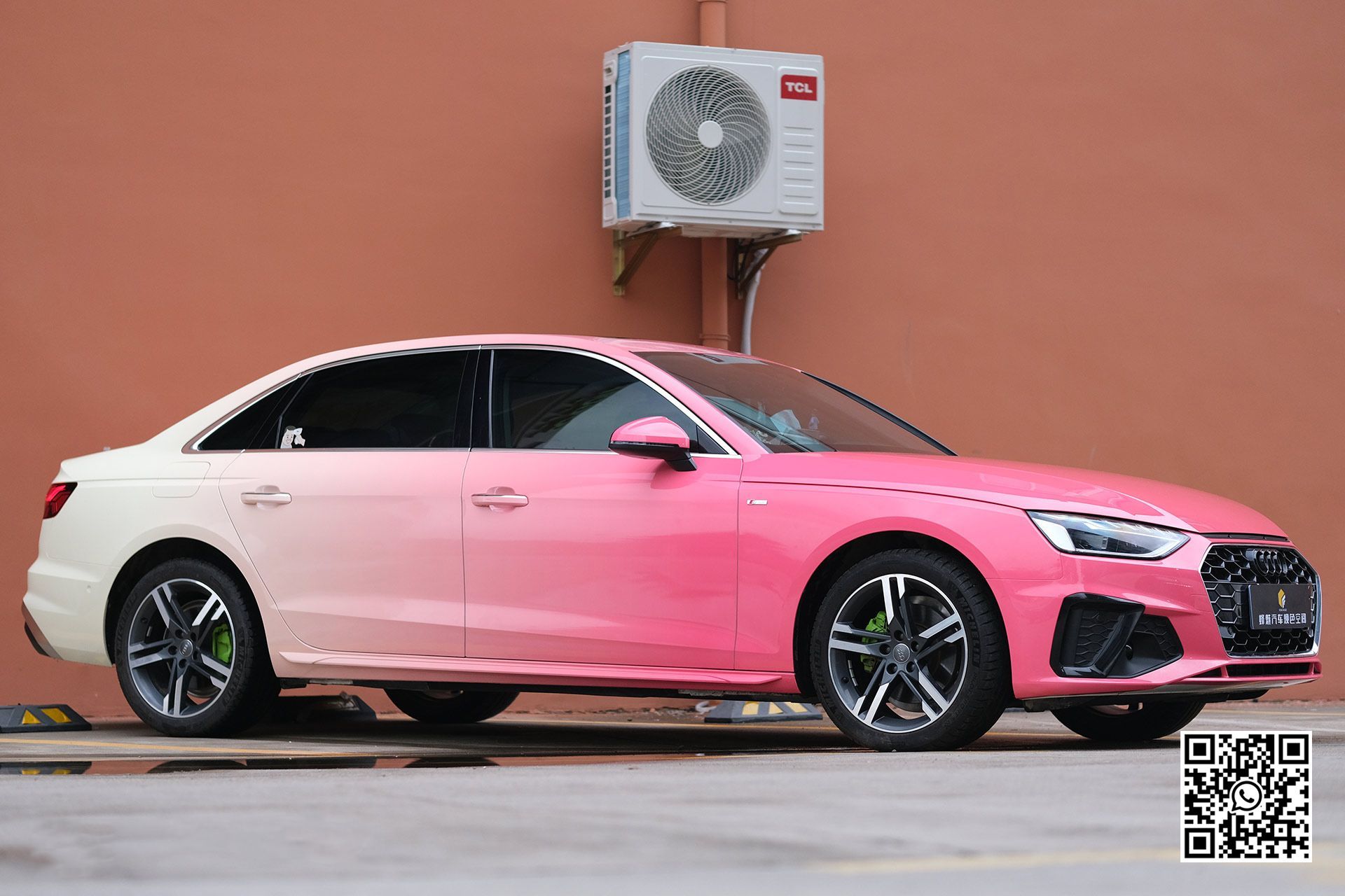 una macchina rosa è parcheggiata davanti a un edificio .