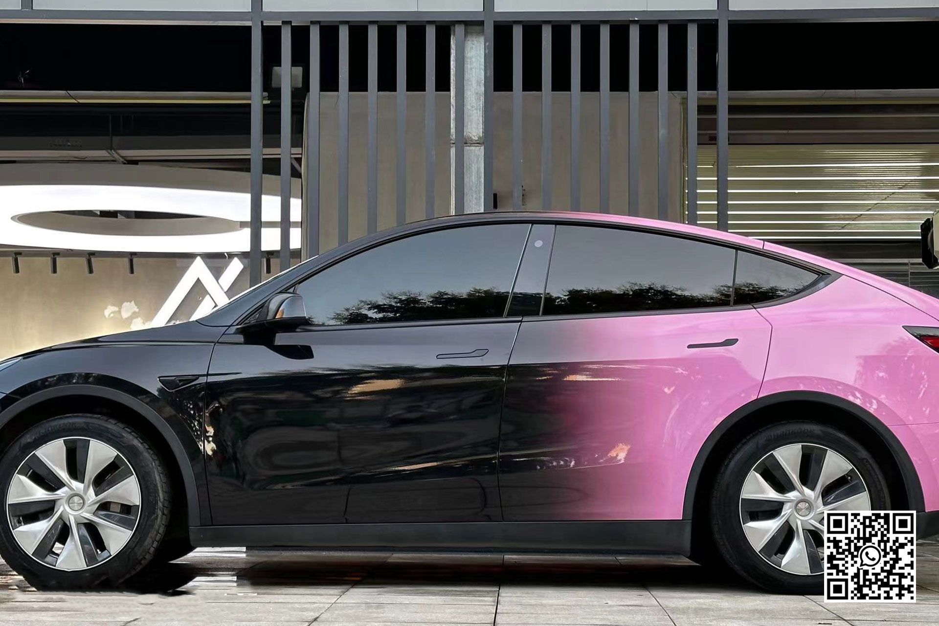 un'auto nera e rosa è parcheggiata davanti a un edificio .