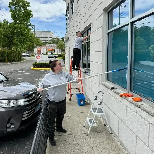 Team cleaning exterior windows of a low-rise commercial building.