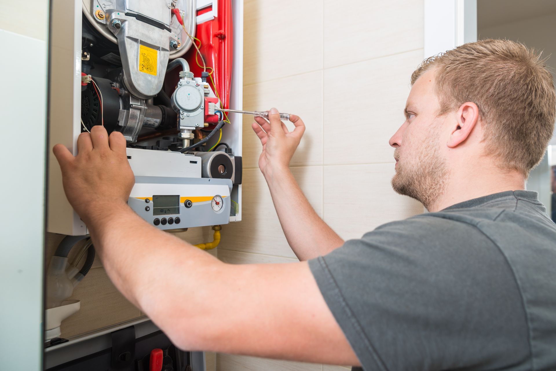 Man Repairing A Furnace - Brighton, Colorado - Top Tier Heating & Cooling LLC