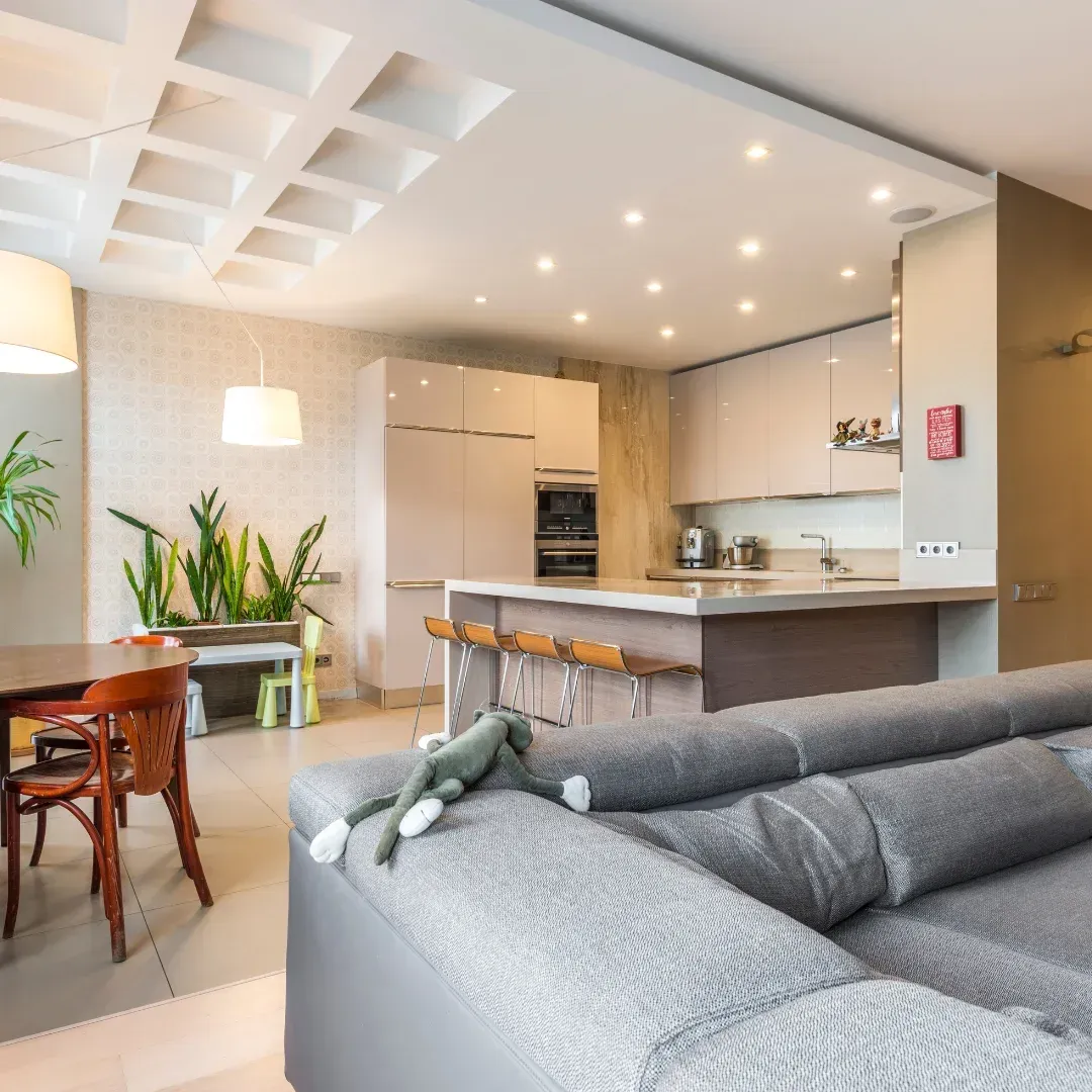A living room with a couch and a kitchen in the background