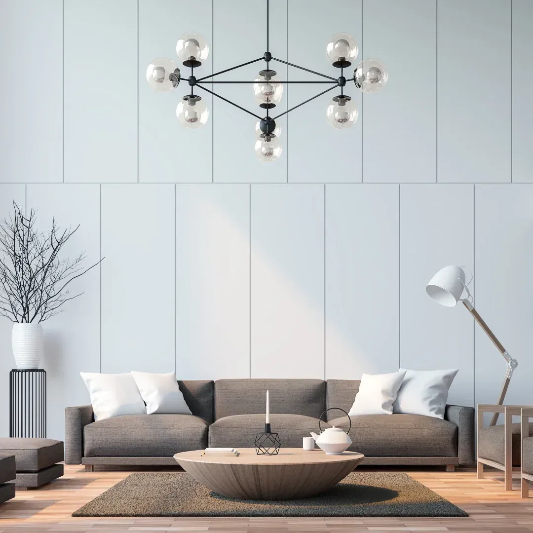 A living room with a couch , coffee table , lamp and chandelier.