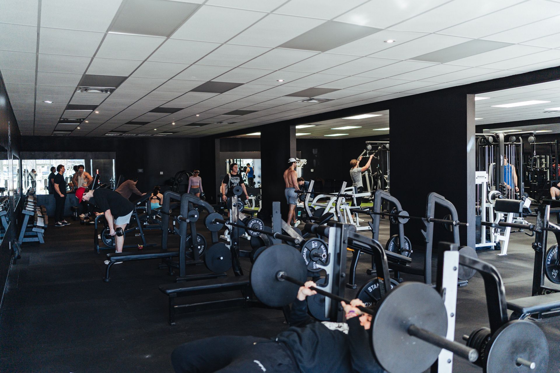 A man is lifting a barbell in a gym.