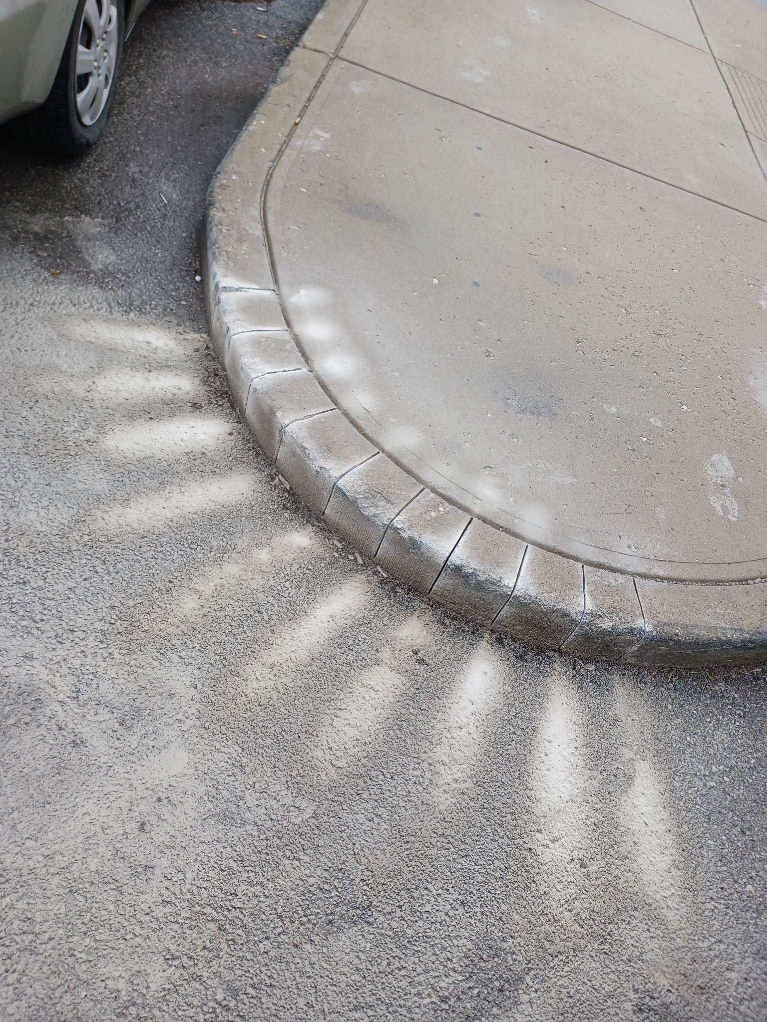 A car is parked on the side of the road next to a curb