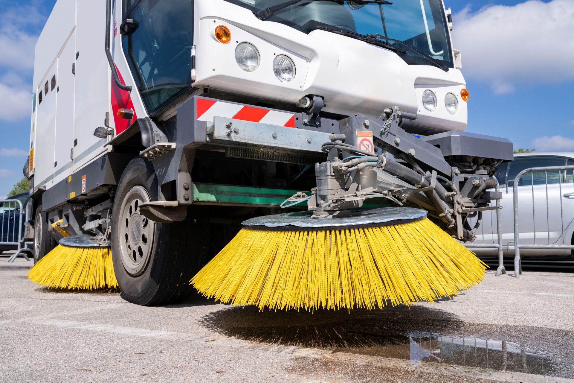 Modern street sweeper truck with yellow brushes providing reliable street sweeping services.