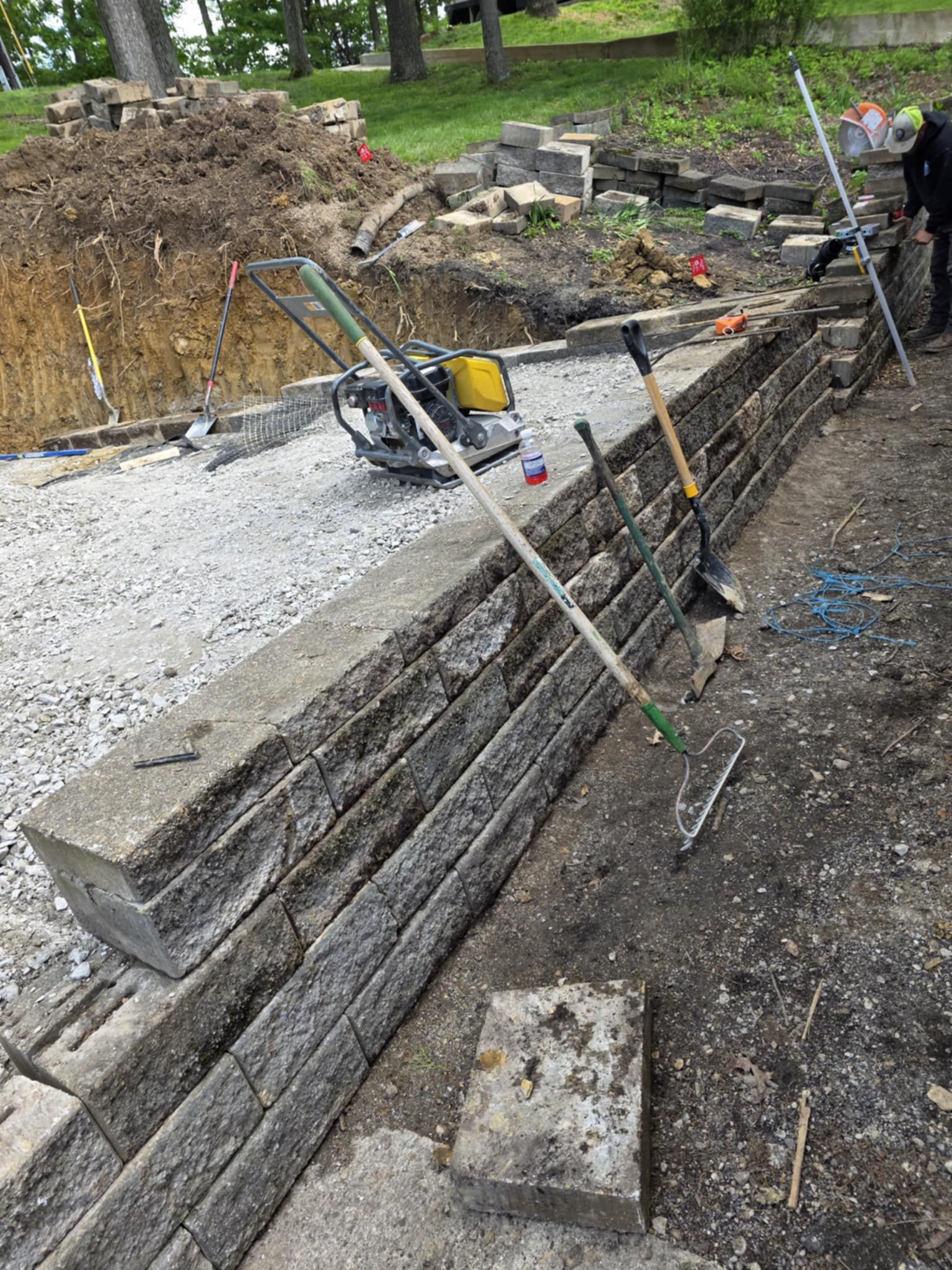 A pile of tools is sitting on top of a brick wall.