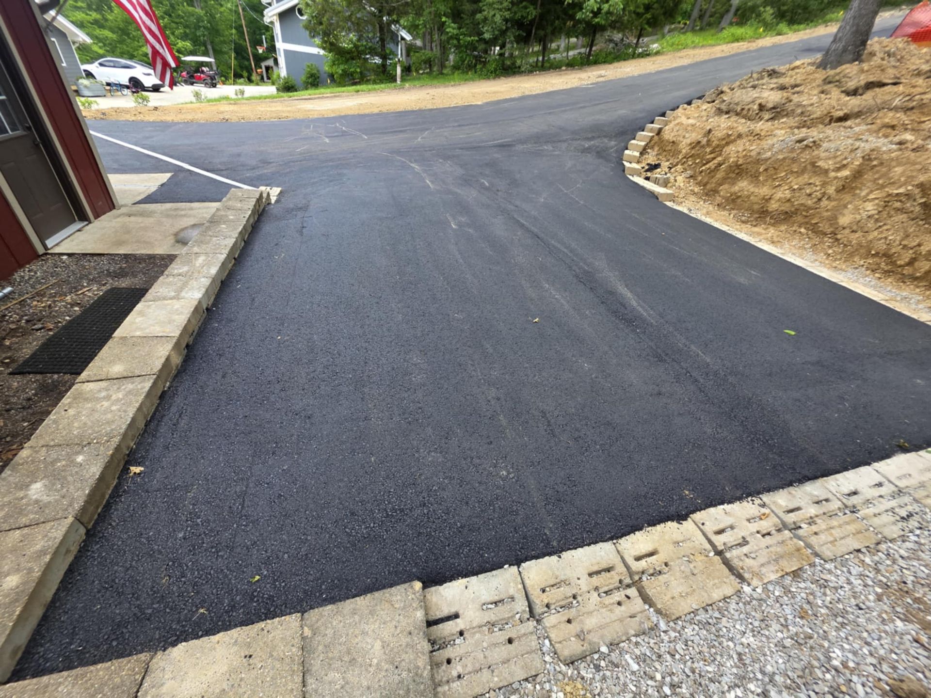 A concrete driveway is being built in front of a brick house.
