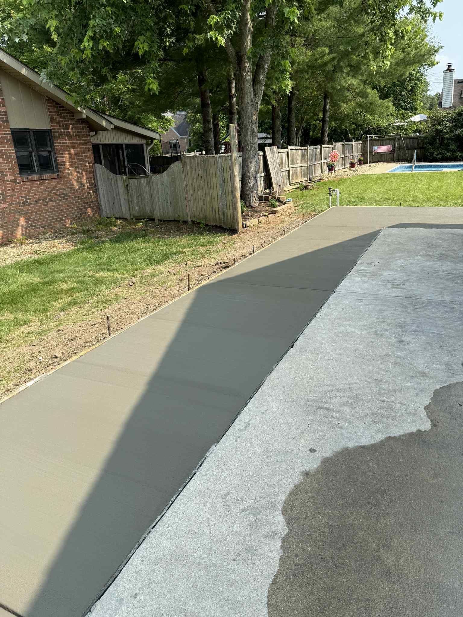 A concrete sidewalk in front of a house.