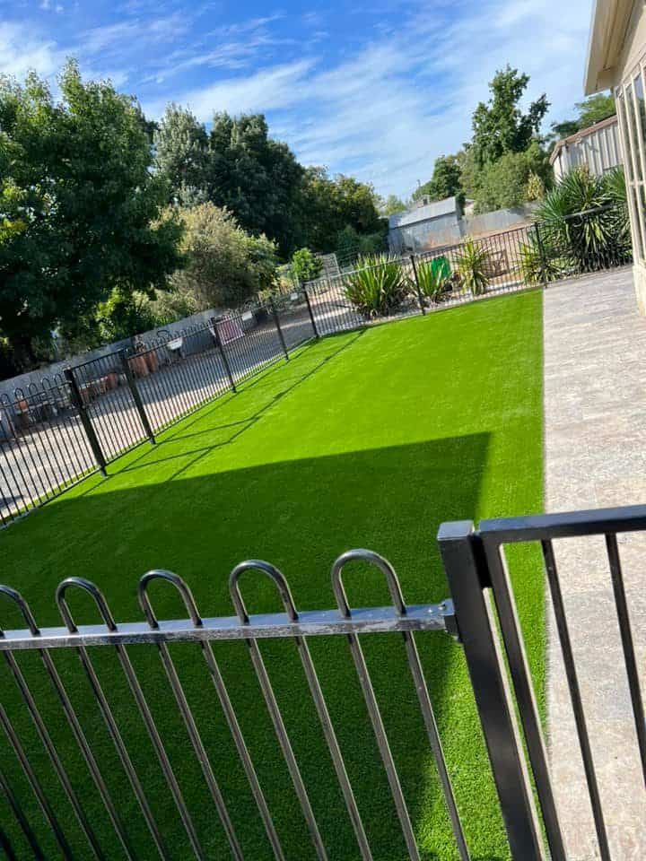 A Fence Surrounds a Lush Green Lawn — Creative Spaces Landscaping in Dubbo, NSW