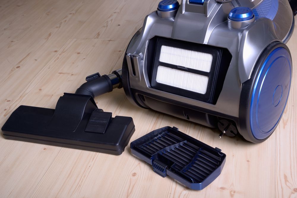Vacuum Cleaner With Filter Cover Open, Lying on Wooden Floor — FNQ Cleaning Services in Mooroobool, QLD