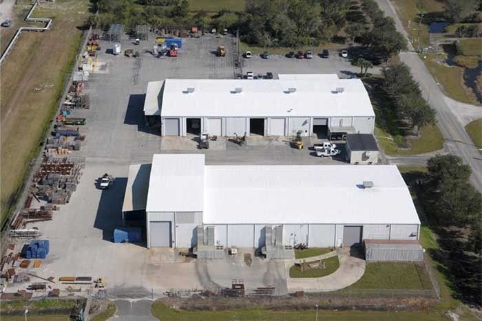 An aerial view of a warehouse with a white roof