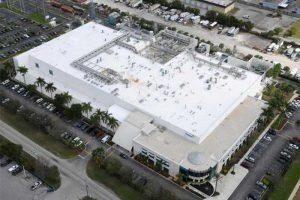 An aerial view of a large building with a white roof.
