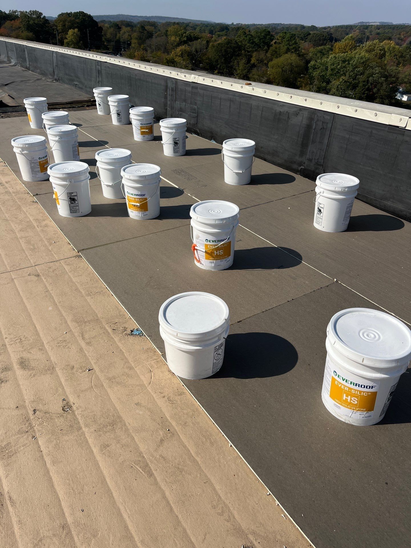 A bunch of buckets are sitting on top of a roof.