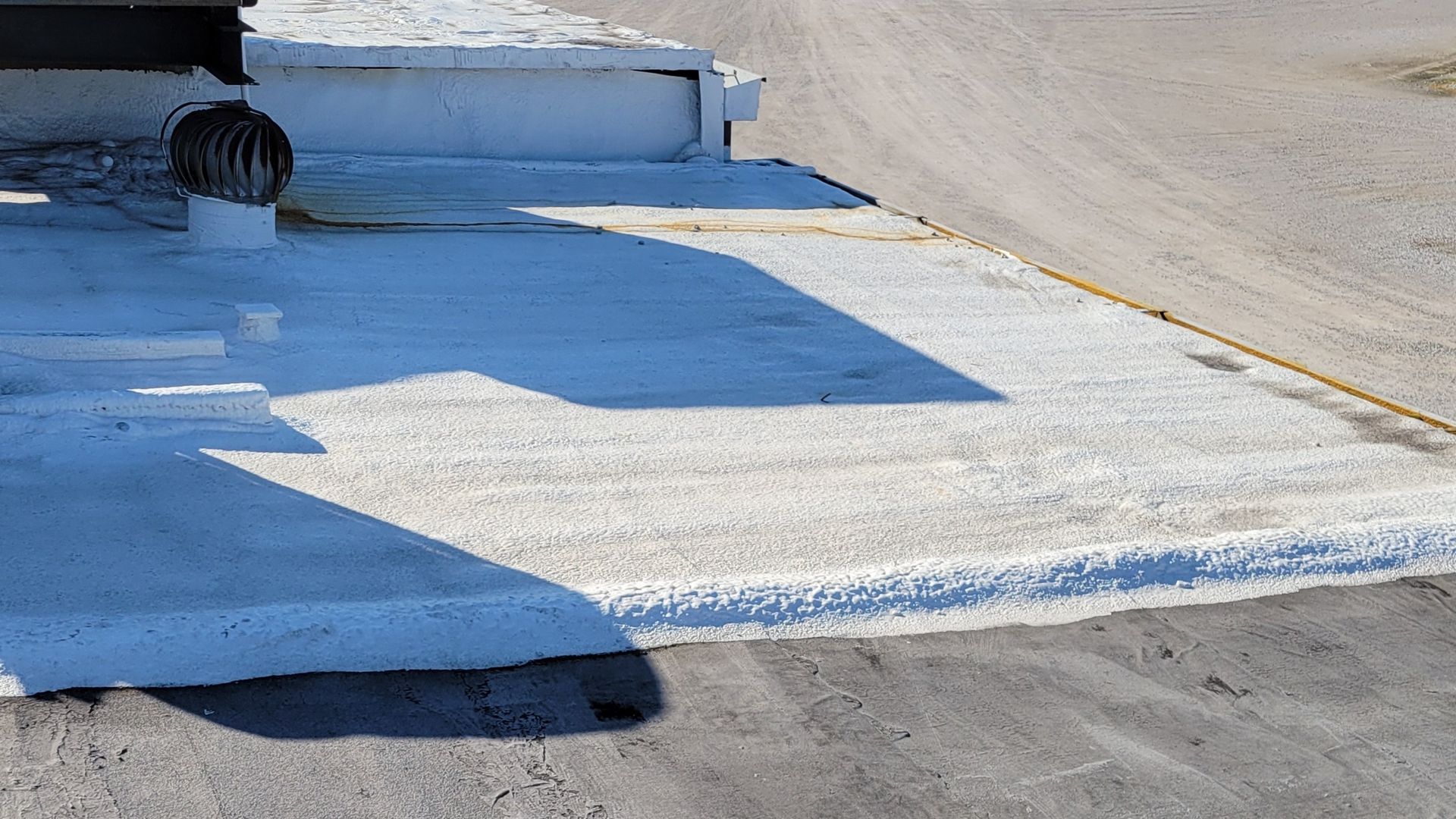 A concrete surface with a white line on it is sitting on the side of a road.