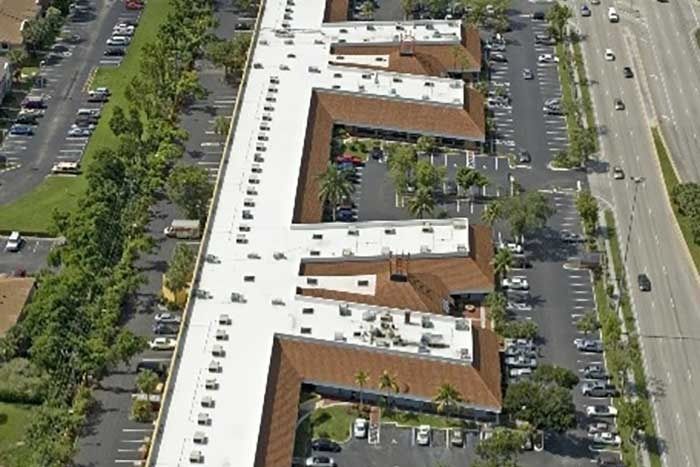An aerial view of a large building with a white roof