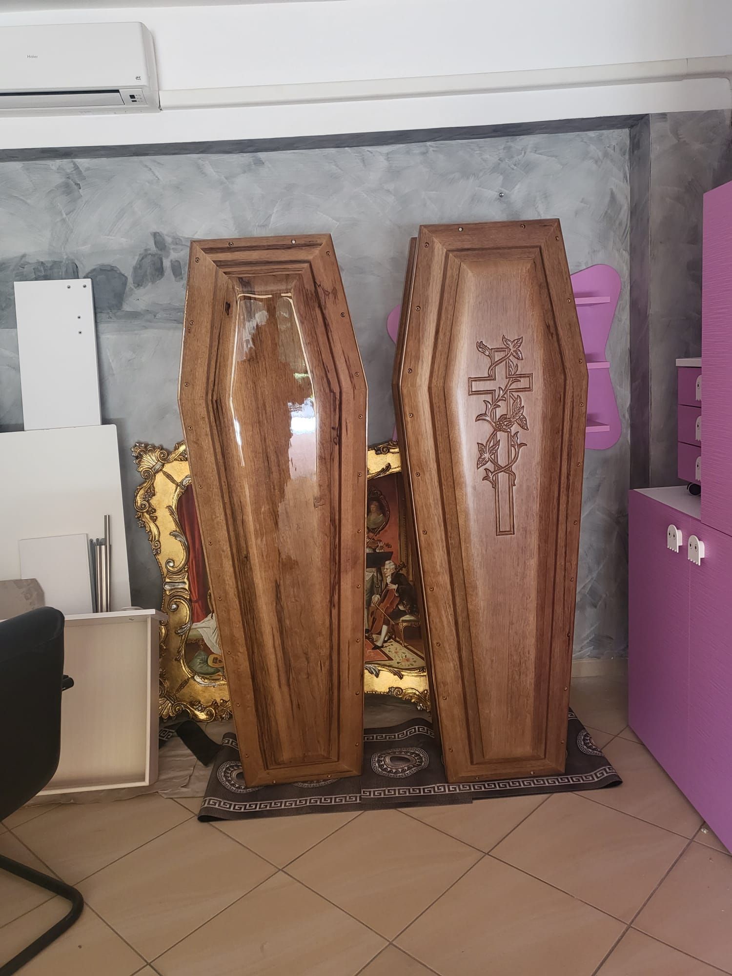 Due bare di legno esposte in una stanza, una delle quali raffigura una croce.