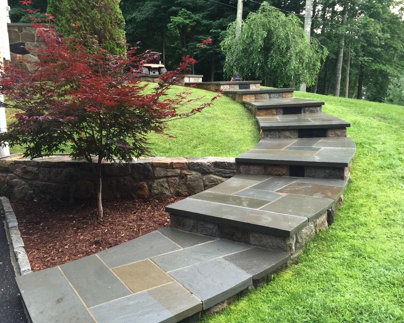 Modern bathroom with glass shower, gray towels, and white walls.