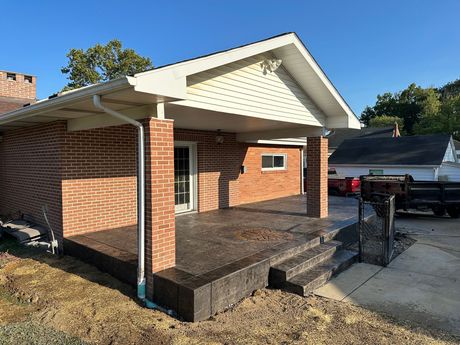 Decorative stamped patio with a stained concrete border and a custom compass stamp stained to match the brick.