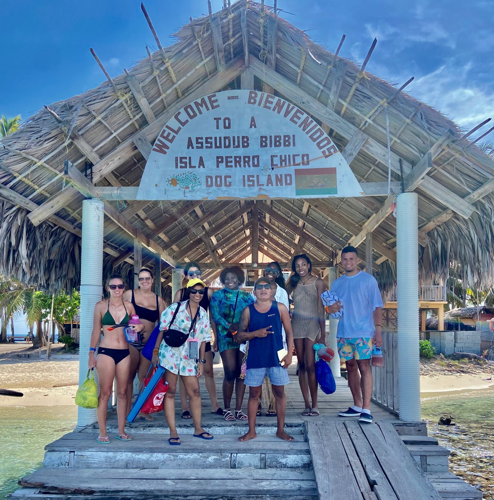 a group of people standing on a dock next to a boat on Perro Chico Island