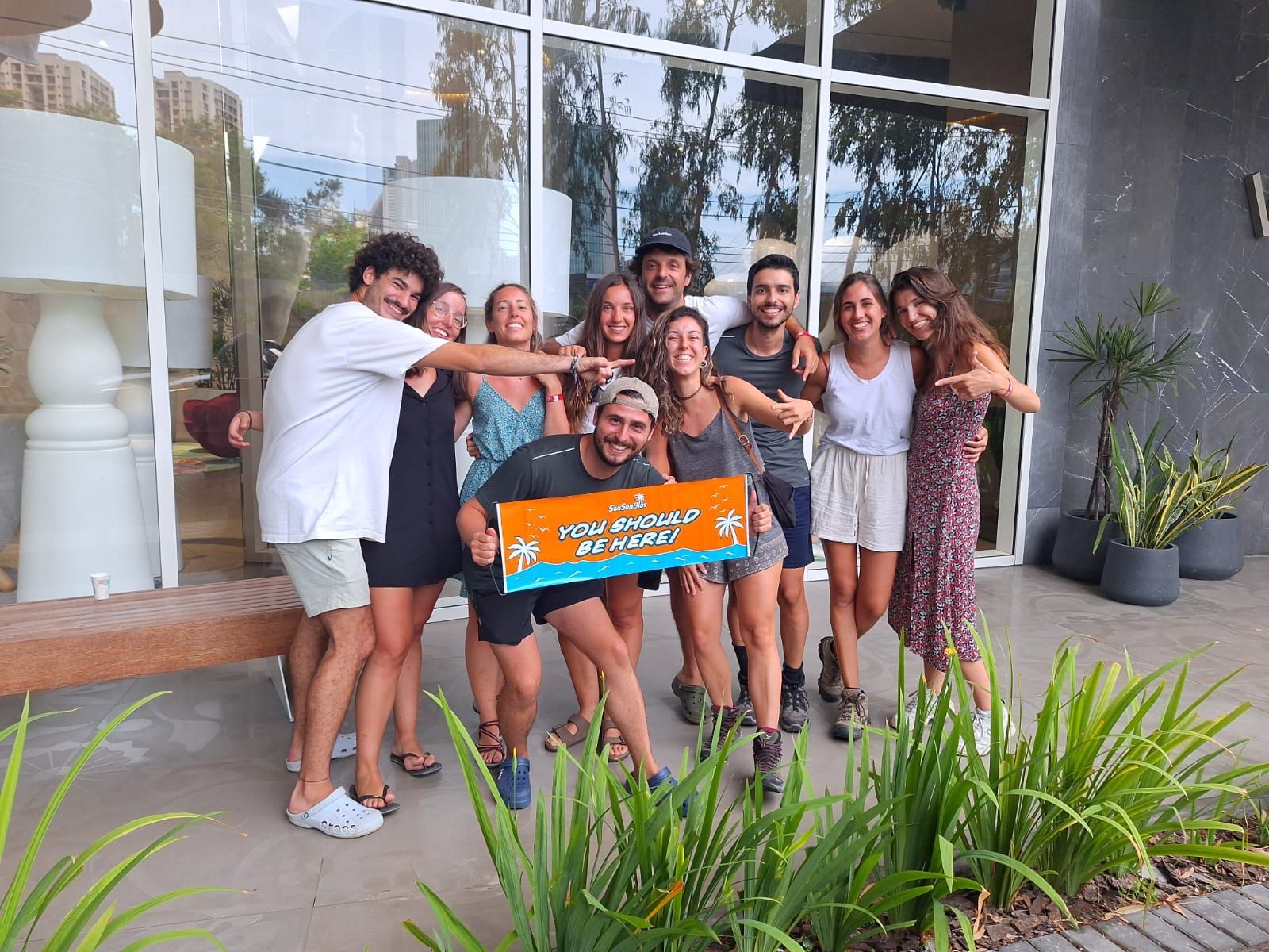 A group of people are posing for a picture in front of a building.