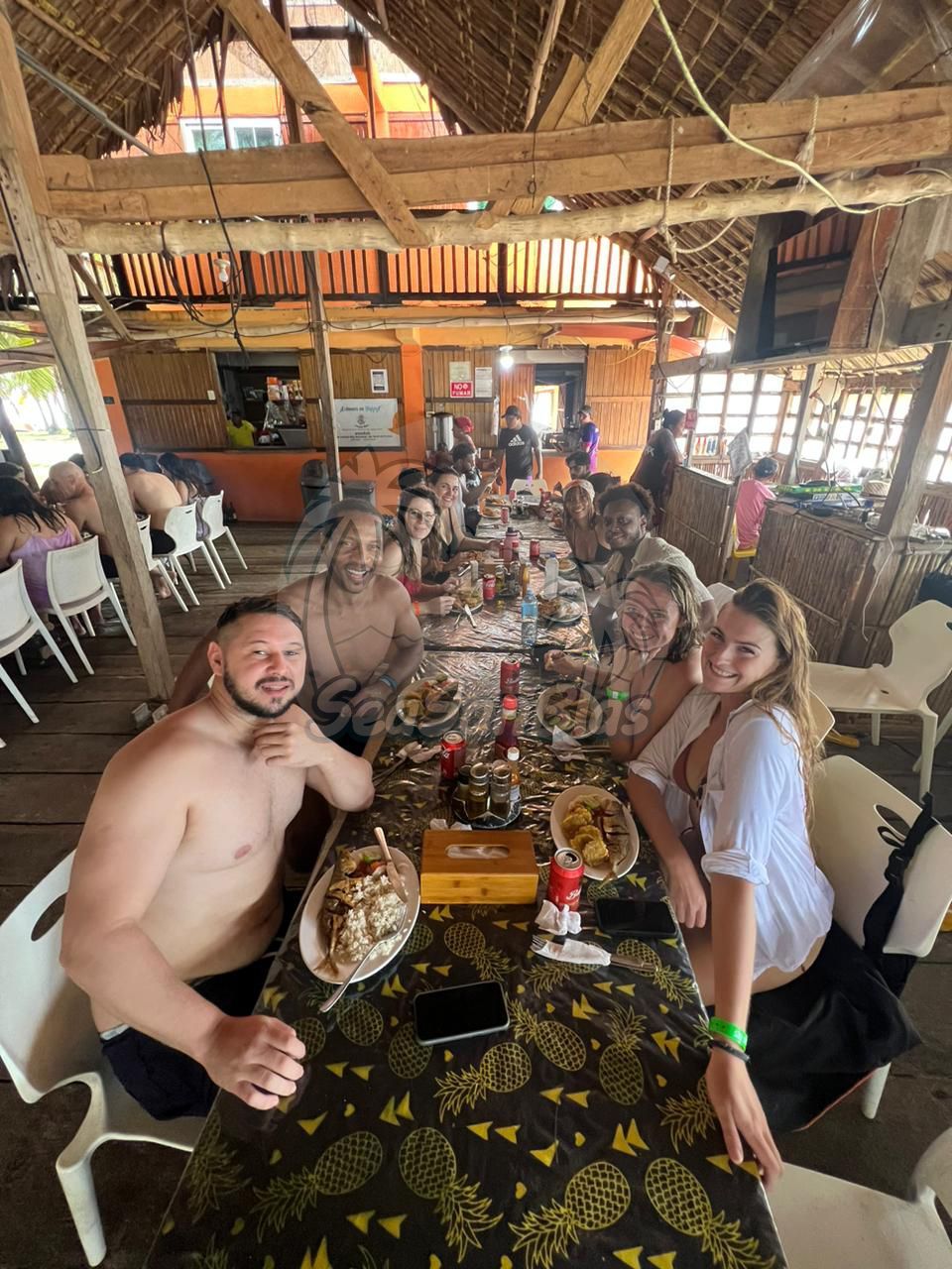 A group of people are sitting at a long table in a restaurant.