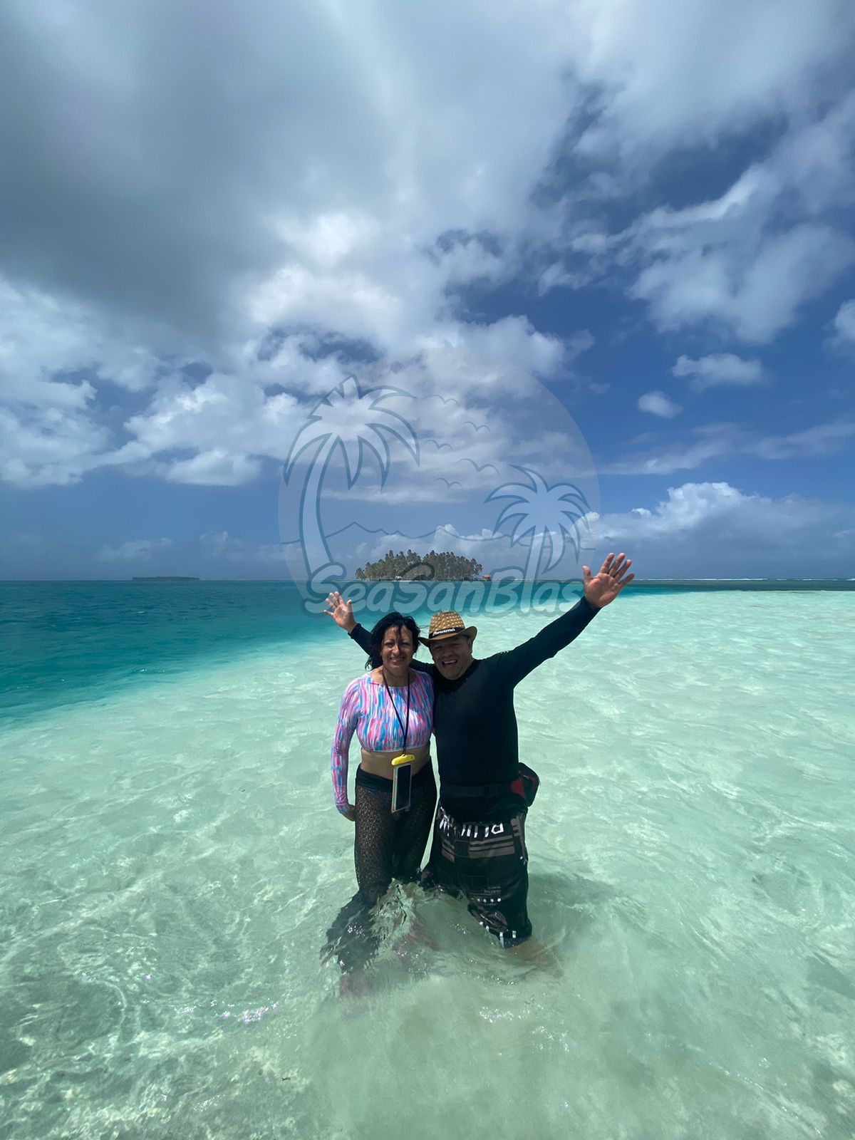 A man and a woman are standing in the ocean with their arms in the air. San Blas Islands Guna Yala San Blas Tours