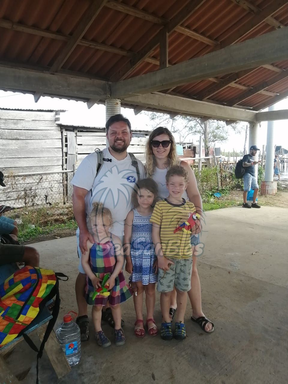 A family is posing for a picture under a roof. San Blas Islands Guna Yala San Blas Tours