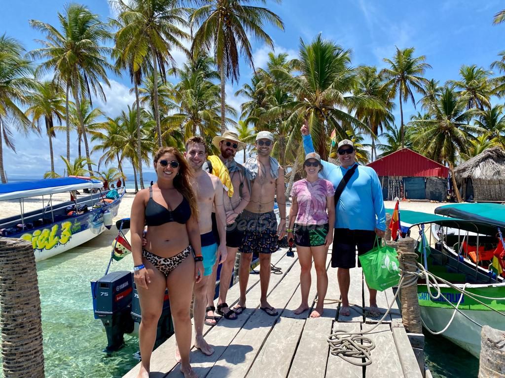 A group of people are standing on a dock next to boats. San Blas Islands Guna Yala San Blas Tours