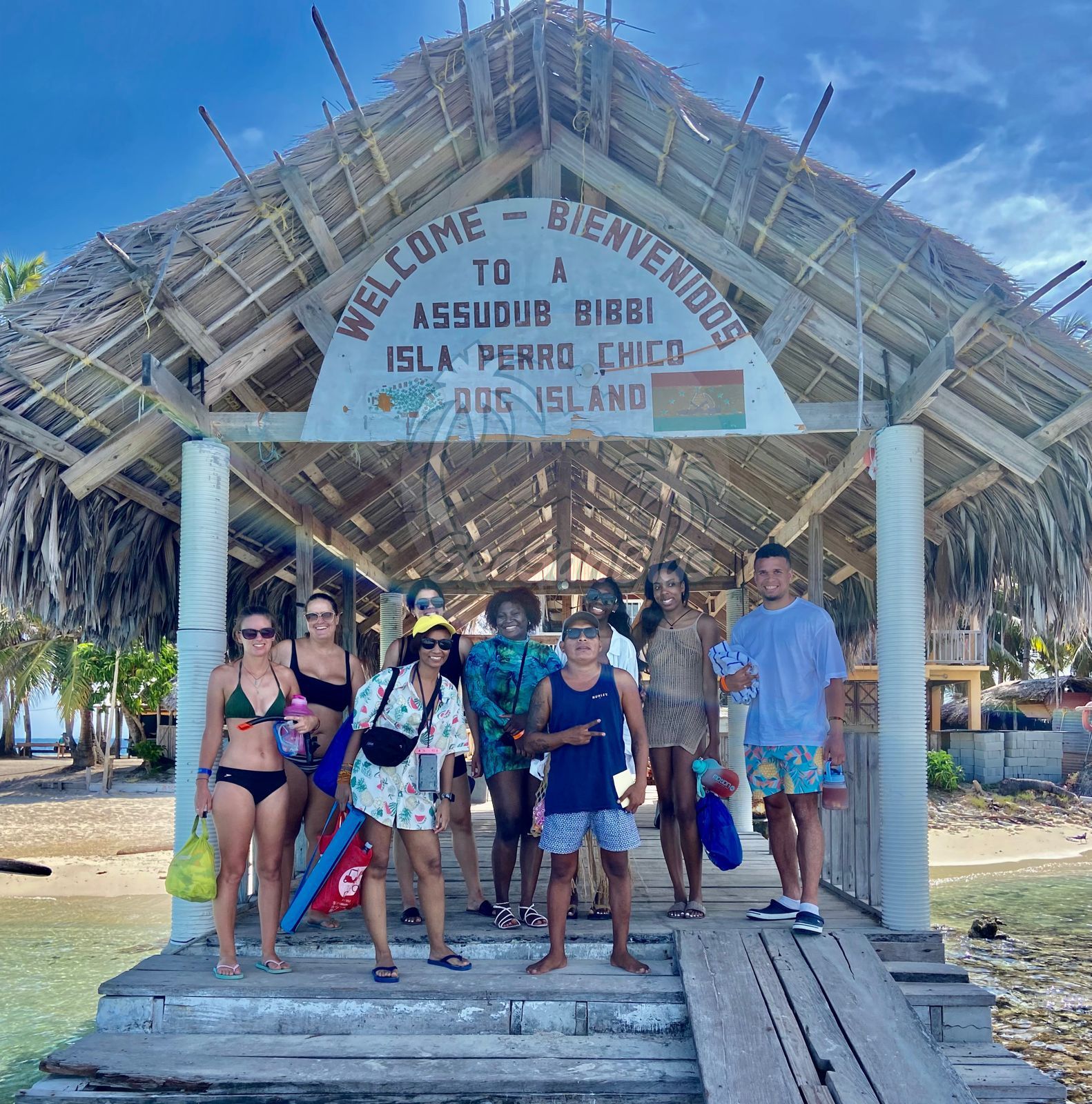 A group of people standing in front of a welcome sign