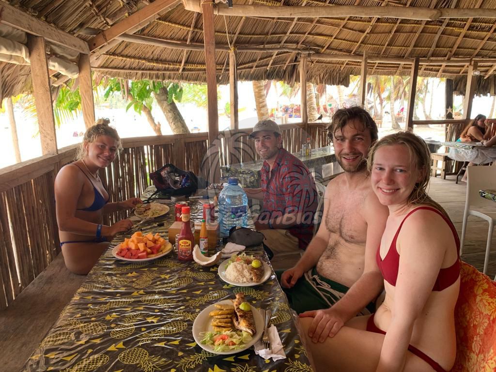 A group of people are sitting at a table with plates of food.