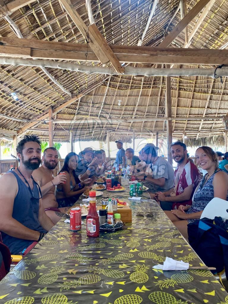 A group of people are sitting at a long table in a restaurant. San Blas Islands Guna Yala San Blas Tours