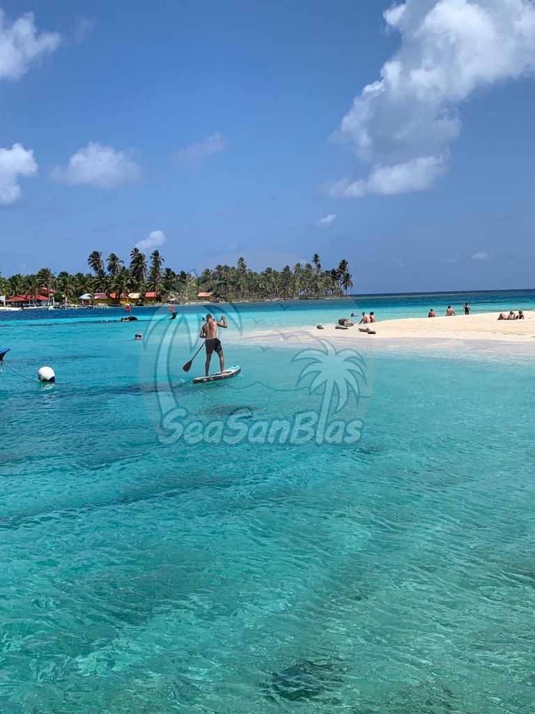 A man is standing on a paddle board in the ocean.