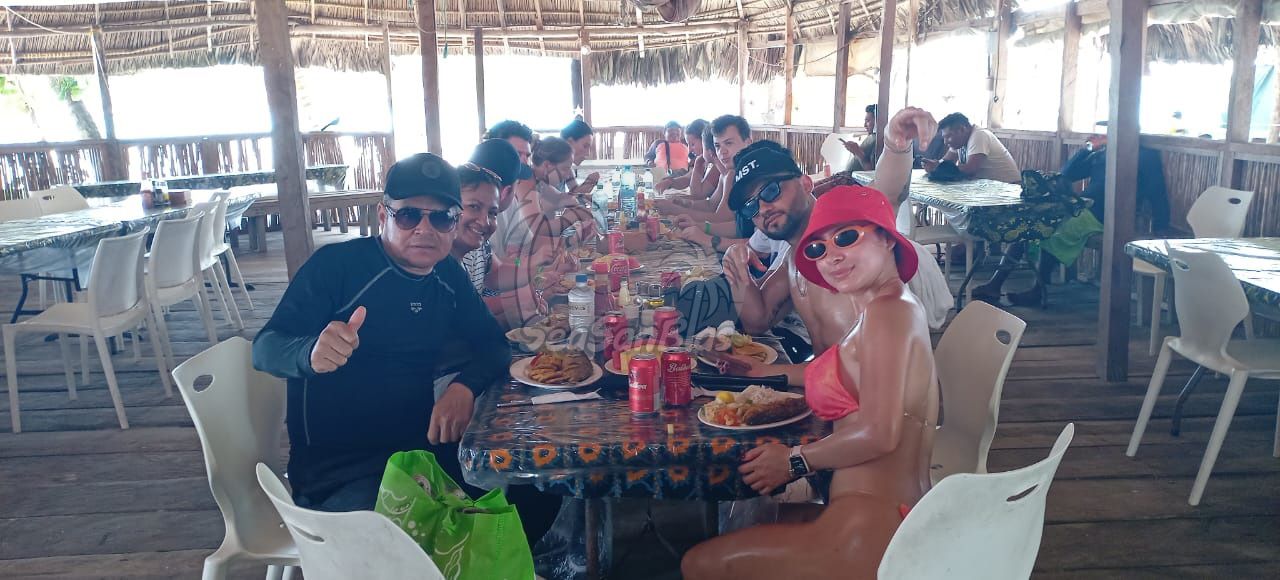 A group of people are sitting at a table in a restaurant eating food.