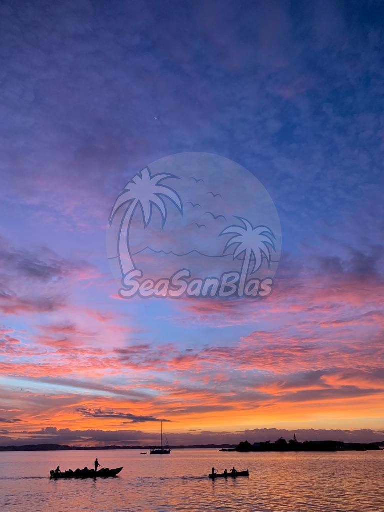 A couple of boats are floating on top of a body of water at sunset. San Blas Islands Guna Yala San Blas Tours
