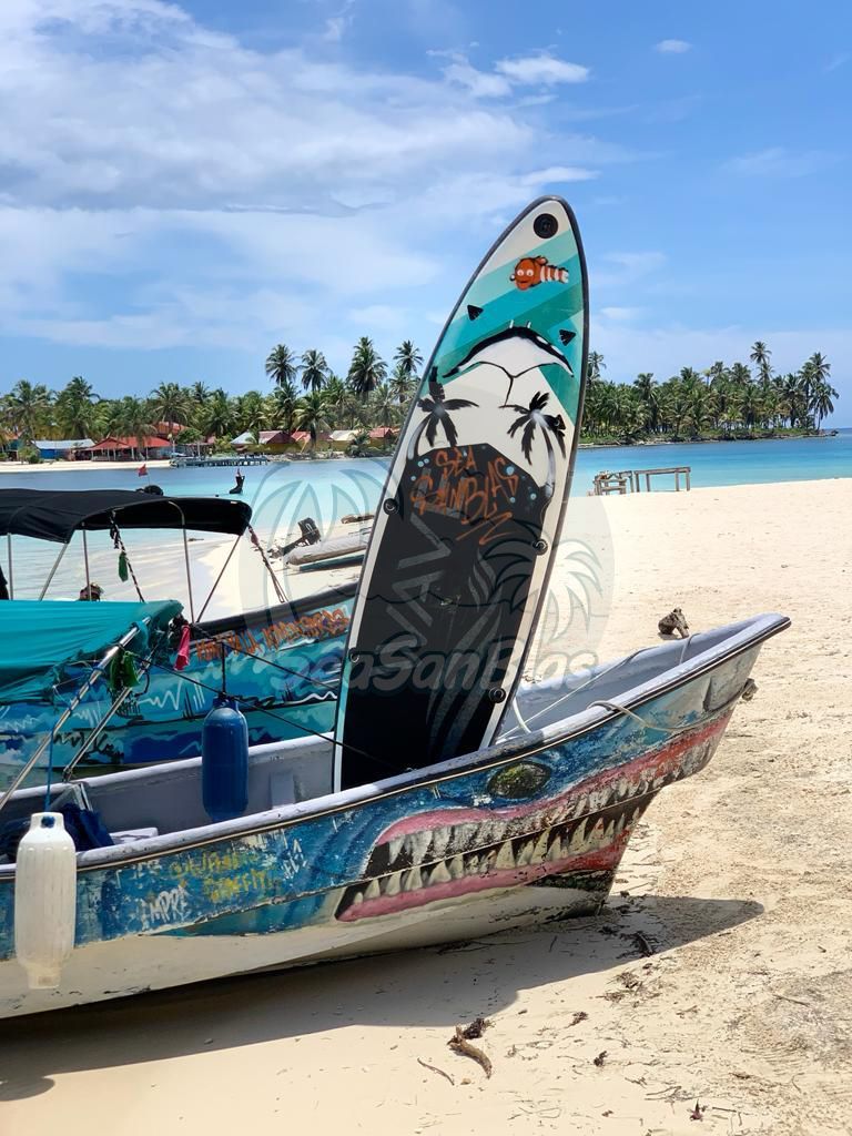 A boat with a surfboard on top of it is on the beach. San Blas Islands Guna Yala San Blas Tours