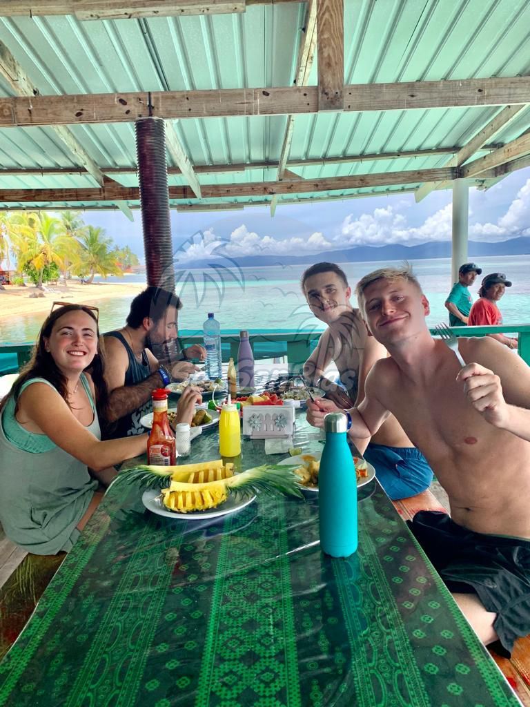 A group of people are sitting at a table eating food.