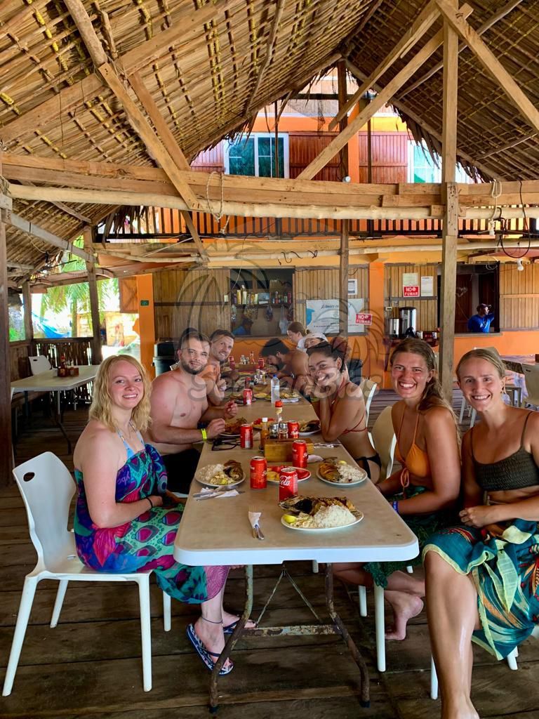 A group of people are sitting at a long table eating food.