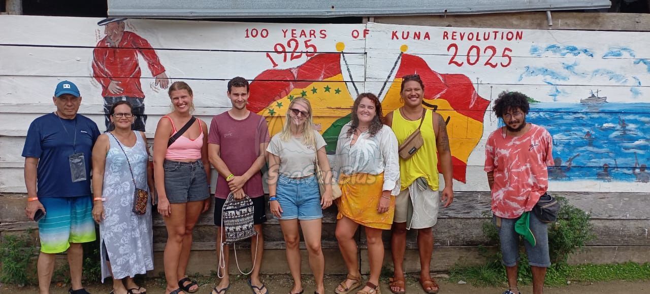 A group of people are standing in front of a mural on a wall.